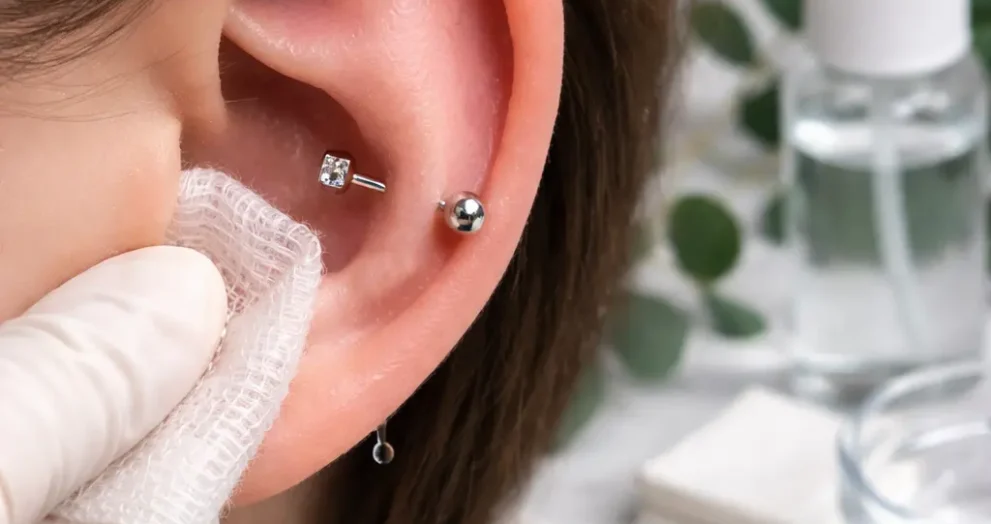 Cleaning a fresh conch piercing with sterile saline and gauze to reduce irritation and support safe healing at home