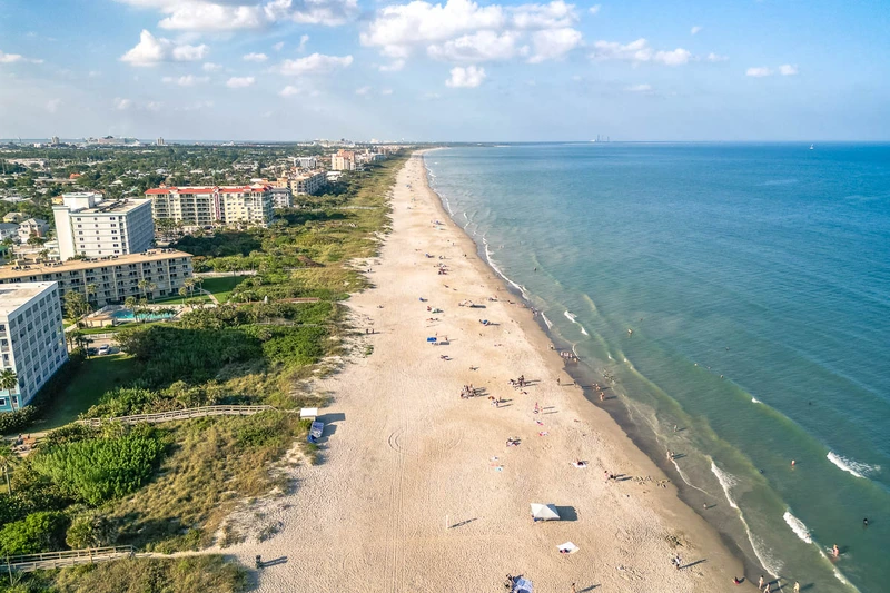 Aerial view of parasailing adventure near Motels Cocoa with Atlantic coastline in background