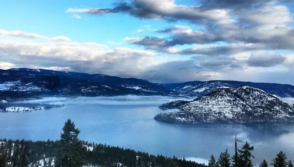 Group enjoying a relaxing holiday celebration with a picnic on scenic hilltop surrounded by mountains and nature